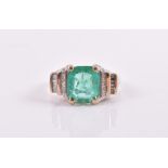 A Colombian emerald and diamond ring four claw-set with a rectangular cushion-cut Colombian