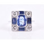 An 18ct white gold, diamond, and sapphire ring in the Art Deco taste, the squared mount centred with