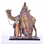 A 20th century cold-painted spelter table lighter modelled as a camel and two attendants, mounted on