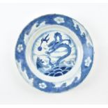 A Chinese Kangxi blue and white porcelain plate decorated with a central scene of a dragon rising