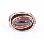 A Georgian yellow gold and enamel mourning ring centred with a garnet cabochon, within a black and