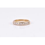 An 18ct yellow gold and diamond ring channel-set with seven princess-cut diamonds of approximately