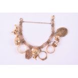 An unusual yellow metal charm bracelet the gate-link bracelet (unmarked, likely 9ct rose gold)