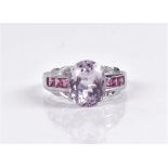 A 14ct white gold, kunzite, and pink sapphire ring set with a mixed oval-cut lilac kunzite, the