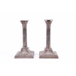 A pair of silver plated candlesticks of Corinthian column form, 26.5 cm high, the bases 13.5 cm