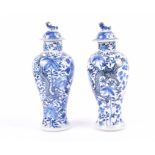 A pair of Chinese blue and white jars with associated covers, of baluster form, depicting dragons