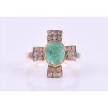 A carved emerald and diamond ring centred with an oval cabochon carved emerald, flanked to each