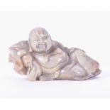 A Chinese carved jade Buddha  modelled in a reclining position with a flowing robe, 9 cm x 5 cm.