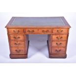 An early 20th century oak pedestal nine-drawer desk  with green tooled leather top, 65 cm high x 122