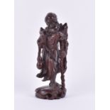 A Chinese carved boxwood figure of a sage, standing on a naturalistic base, 27.5 cm high x 10.5 cm