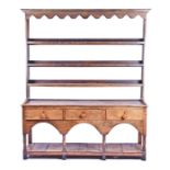 A 19th century and later oak kitchen dresser with three plate shelves over a three-drawer base and