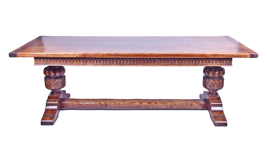 A large 18th century style oak refectory table the plank top supported on very large turned and