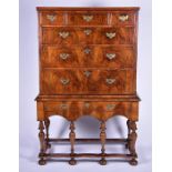 An 18th century walnut chest on stand the top with three short and three long graduated drawers, all