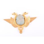 An ancient Egyptian scarab set in high carat gold designed as flying serpents with ruby eyes,