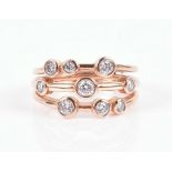 An 18ct rose gold and diamond ring in the style of Boodles, the triple gold band with individual