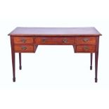 An Edwardian mahogany writing desk the rectangular top with moulded rim, over a central drawer and