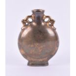 A small Chinese gold glazed vase of moon flask form with twin handles, the body decorated with