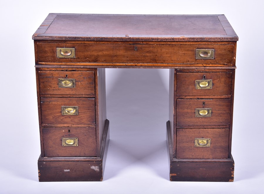 An Edwardian oak nine drawer pedestal desk with brass campaign handles, 101 cm x 79 cm x 54 cm.