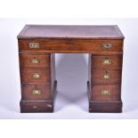 An Edwardian oak nine drawer pedestal desk with brass campaign handles, 101 cm x 79 cm x 54 cm.