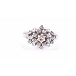 A white gold and diamond cluster ring the raised cluster centred with a round-cut diamond,