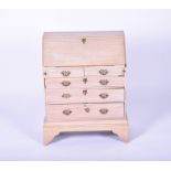 A 20th century child's stripped-wood small bureau the drop opening to reveal a compartmentalised