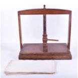 An early 20th century oak book press together with a quantity of loose paper, 57 cm high x 61 cm