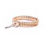 A yellow metal bangle bracelet of folded curb links, stamped indistinctly to interior of shank,