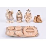A group of Japanese Meiji period ivory figural netsukes including three figures wearing kimono,