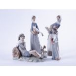 A collection of four Lladro figures comprising  a young boy leaning against a log, two girls holding