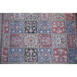 A large Persian (possibly Caucasian) rug with checkerboard pattern and ornate border with