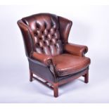 A contemporary leather upholstered wing-back armchair with button back, 109 cm high x 85 cm wide,
