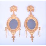 A pair of Continental giltwood girondelles probably Italian, with oval shaped mirrored backs,