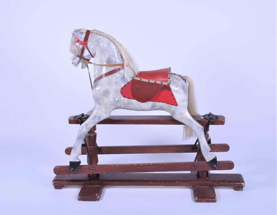 An early 20th century painted rocking horse with padded leather saddle and bridle, on rocker base