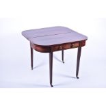 An Edwardian mahogany fold over table with inlaid banding around the shaped top, opening to reveal a
