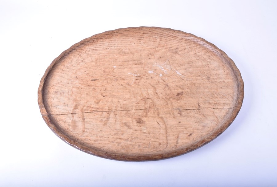 An Arts & Crafts style oak serving tray by Stanley Webb Davies with a shaped piecrust rim, the