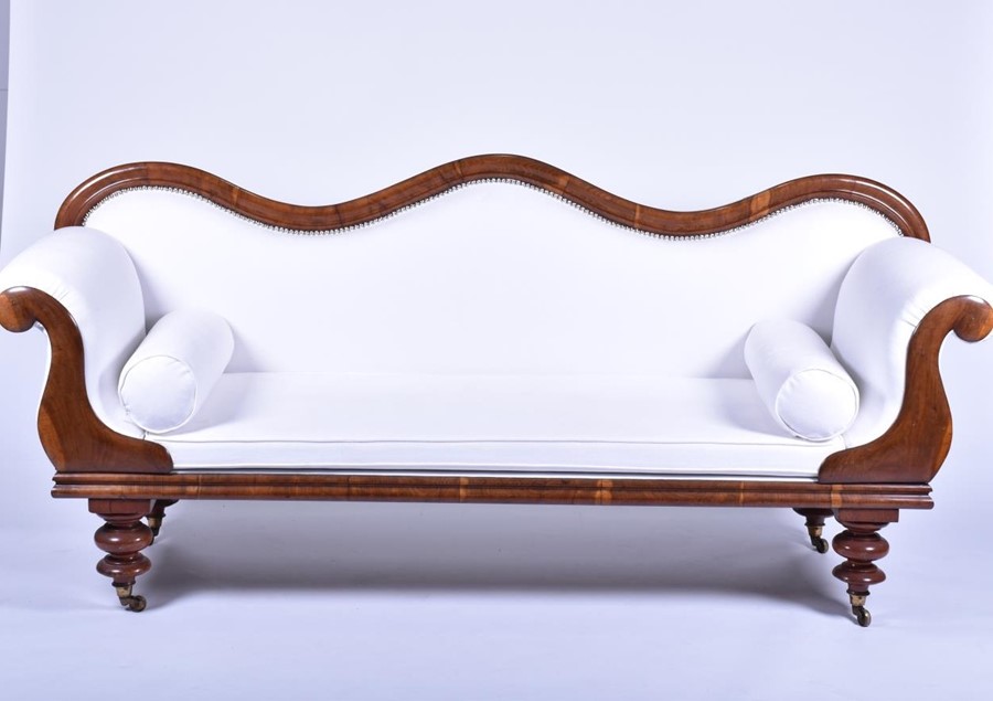 A Regency double scroll end mahogany settee upholstered with white fabric, the frame designed with
