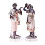 A pair of Victorian terracotta painted figures of African musicians the man holding a mandolin,