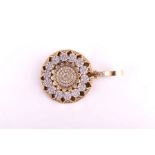 An unusual 14ct yellow gold and diamond pendant of circular form, decorated with floral motifs, 3.