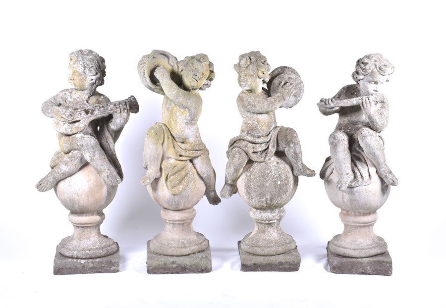 A set of four 20th century Italian musical cherub stoneware sculptures each seated on a sphere,