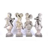 A set of four 20th century Italian musical cherub stoneware sculptures each seated on a sphere,