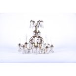 A French Belle Epoque cut glass chandelier comprising eight lights, the scrolled arms with hanging