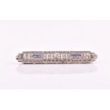 A diamond and sapphire bar brooch in the Art Deco style, centred with a round-cut diamond of