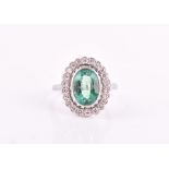A platinum, diamond, and emerald ring set with a mixed oval-cut emerald of approximately 2.40