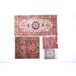 A small group of Persian silk rugs to include an Isfahan silk runner with cream and orange tones,