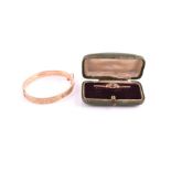 A 9ct yellow gold bangle with engraved decoration, internal diameter 5.8 cm, together with a