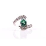 A diamond and emerald crossover ring set with a pear-cut emerald, the crossover band pave-set with