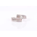 An 18ct white gold and diamond crossover ring set with round- and baguette-cut diamonds, size P, 3.8