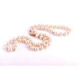 A pearl necklace comprised of cultured white pearls, fastened with a 9k yellow gold clasp,