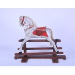 An early 20th century painted rocking horse with padded leather saddle and bridle, on rocker base