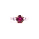 An 18ct white gold, diamond, and ruby ring set with a mixed oval-cut natural ruby of approximately